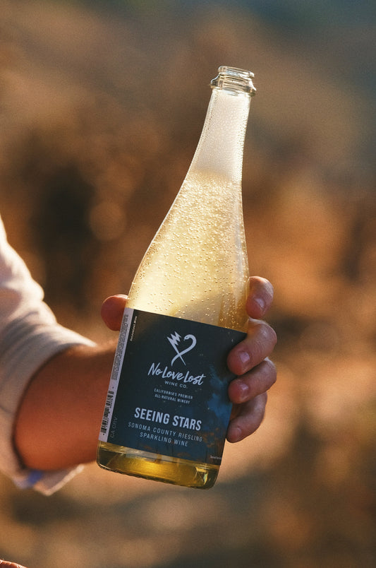 2025 No Love Lost Sparkling Riesling — Dry Creek Valley AVA, Sonoma County. East-facing vineyard above the fog line with blue slate soils and cool Pacific influence. Brioche, stone fruit, pineapple, and petrol notes with lively effervescence. Versatile natural sparkling wine, pairs with salads, ribeye, or desserts. 11.9% ABV.